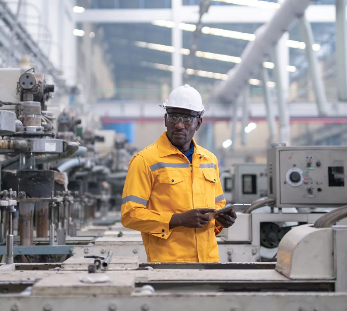 Engineer in safety gear reviewing data on a tablet